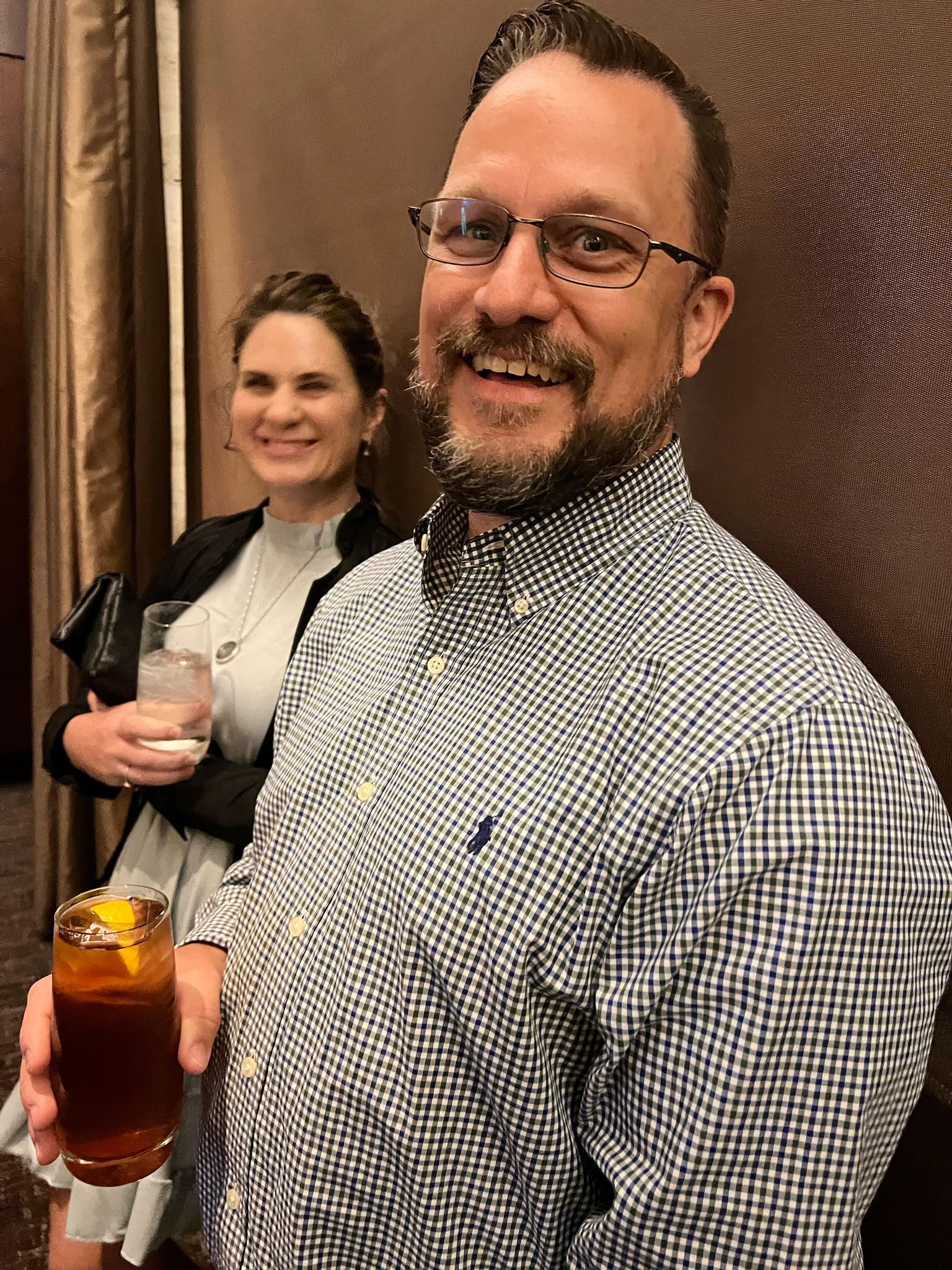 Guests at reception leaning against wall smiling for camera 