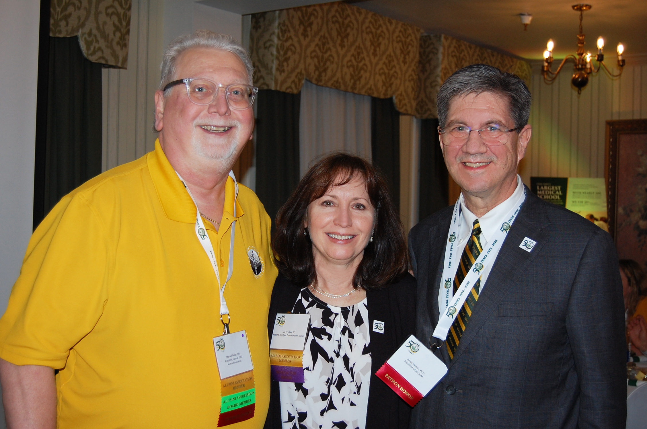 Dr. Nemitz with two other attendees. Names not visible, both denote alumni association members, one also states board member.