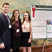 Three students in front of their winning research project