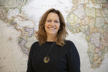 Katherine Calloway, D.O., MPH, WVSOM regional assistant dean, stands in front of a world map.