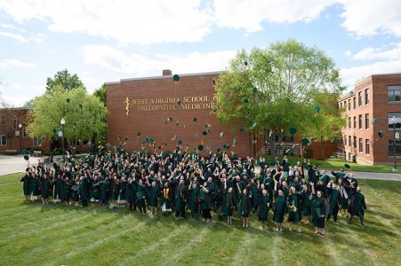 New graduates toss their caps into the air