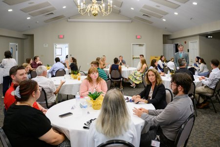 Students gathered at tables for a reception